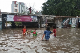 Anak-anak bermain air banjir di Underpass Gonggo, Dusun Jatirasa Tengah, Kelurahan Karangpawitan, Kabupaten Karawang, Sabtu (20/2/2021). Kompas.com/Farida
