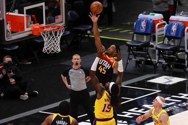 Donovan Mitchell berusaha memasukkan bola ke dalam ring melewati Montrezl Harell. Foto: USA Sports Today/Chris Nicoll