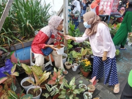 Seorang Ibu bertransaksi dengan penjual bunga di depan di depan Pasar Tradisional Higienis Bahari Berkesan Ternate. Minggu (28/2/2021)/Dokumentasi pribadi