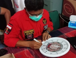 Masrin Marbun, Ketua DPC Jakarta Barat membubuhkan tanda tangan di jam dinding untuk diserahkan kepada Herry. Foto (istimewa/dokpri)