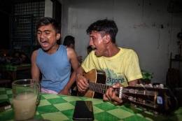 Beberapa anak muda bernyanyi di Lapo dengan gelas berisi Tuak. Foto: Beritatagar.id 