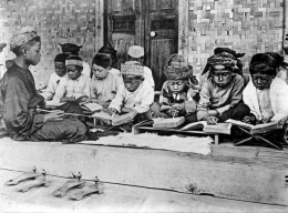 A photo taken in a Javanese madrassah in the Dutch Colonial period. Left hand corner of the picture shows two pairs of wooden Javanese clogs. In Cape Town, these were called kaparangs and could be found in many old masjids in cape town. Also notice the manner of teaching and learning the holy Quran, using a 'kalam' (wooden stick) to point. this method still used in many old-school madrassahs in cape town. Also the usage of melayu terms for arabic vowels - fat'ha = dettis (di atas), Kasrah = bawah, Dommah = dapan, tanween = dua dettis, dua dapan, dua bawah, Shaddah = saptu (Sumber: https://www.sites.google.com/site/aljaamiahacademy)