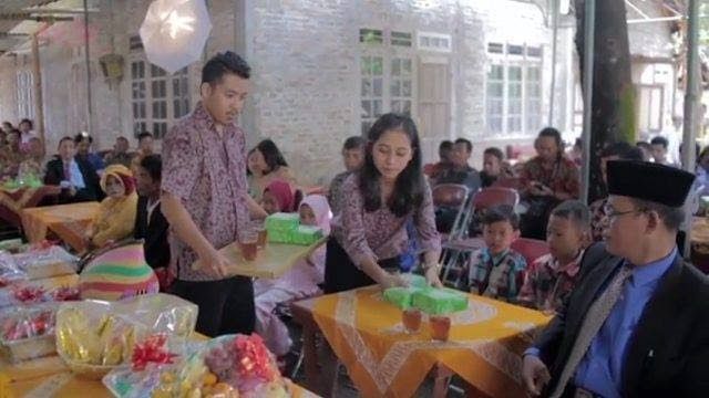 Sinoman pria membawa baki hidangan, sinoman wanita yang menyajikan. Foto: Facebook Kominfo DIY
