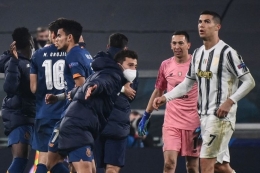 Ekspresi bintang Juventus Cristiano Ronaldo saat pemain FC Porto merayakan kelolosan mereka dari babak 16 besar Liga Champions 2020-2021 di Stadion Allianz, 9 Maret 2021. (Foto: AFP/MARCO BERTORELLO via kompas.com)