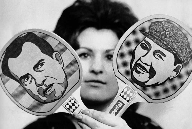 Seorang perempuan yang menujukkan bet ping-pong dengan gambar Richard Nixon dan Mao Zedong | Foto diambil dari Pbs.Org