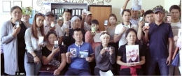 Orang-orang Uighur menunjukkan foto-foto anggota keluarga mereka yang telah hilang atau sedang di dalam penjara dalam sebuah aksi protes melawan China di suatu kota di luar China. | Sumber: Amnesty International