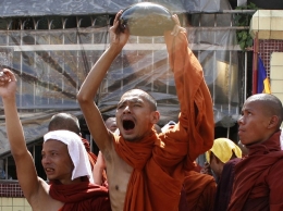 Seorang biksu yang membalikkan mangkuk persembahan sebagai bentuk protes ketika Revolusi Saffron | Foto diambil dari Reuters/Landov