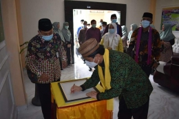 Kakanwil Sulteng Rusman Langke saat membuhkan tanda tangan sebagai pertanda kunjungan kemenag sulteng di MTsN 1 Kota / dokpri