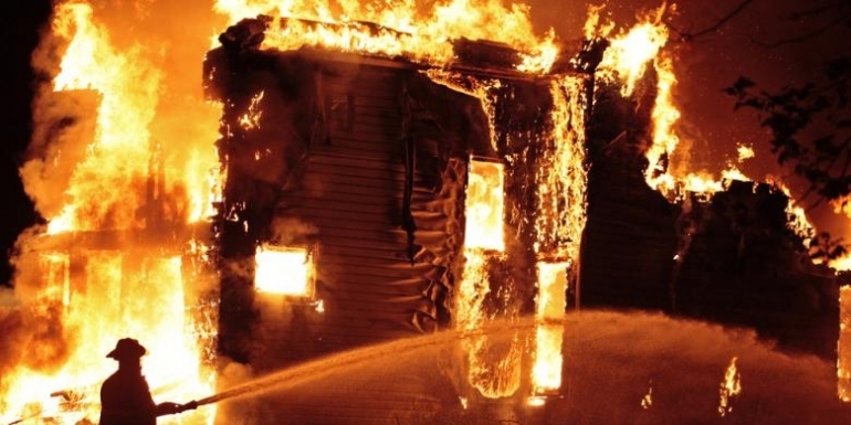 Ilustrasi petugas sedang memadamkan rumah yang terbakar. Sumber: Shutterstock via KOMPAS.COM