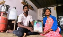 Latha Bollapally dan putranya Rajesh Goud, memegang foto suaminya, Madhu Bollapally, 43, pekerja migran yang tewas di Qatar. | Kailash Nirmal TheGuardian.com