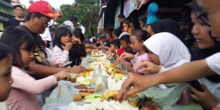 Warga Warujajar, Cianjur, Jawa Barat menyantap nasi liwet bersama-sama di sepanjang Jalan Hasyim Asyari, Rabu (01/05/2019) petang dalam rangka Papajar menyambut datangnya bulan Ramadan(KOMPAS.com/FIRMAN TAUFIQURRAHMAN)