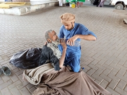 ILUSTRASI: Seorang pria  sedang memberikan minum kepada seorang kakek | sumber: pexels.com
