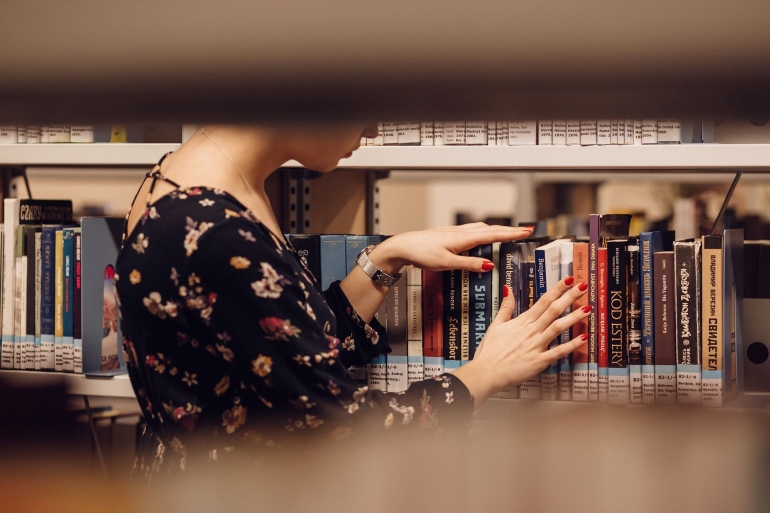 Ilustrasi perempuan yang sedang memilih buku bacaan di perpustakaan. (sumber: pixabay.com/freestocks-photos)