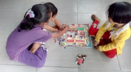 Tiga orang anak sedang memainkan permainan monopoli. (liputan6.com)