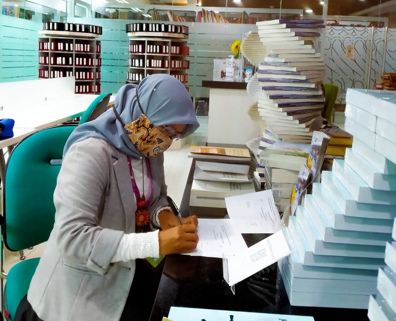 Kiki sedang mengisi formulir pengambilan buku terbitan Perpusnas Press di lantai 14, Perpustakaan Nasional RI (Foto: dok. Kiki)