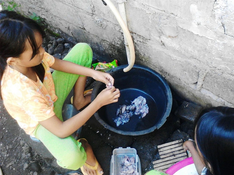 Teh Puput membersihkan cumi kecil sebelum memasak cumi lada hitam ala Nenek Jakarta (Dokpri).