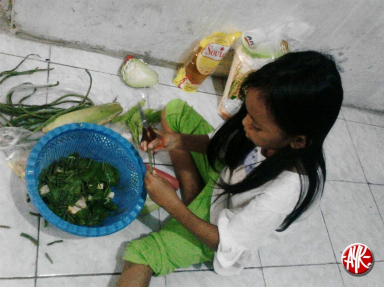 Kakak Tya kebagian memotong bahan untuk sayur asem ala Ema (dokpri)