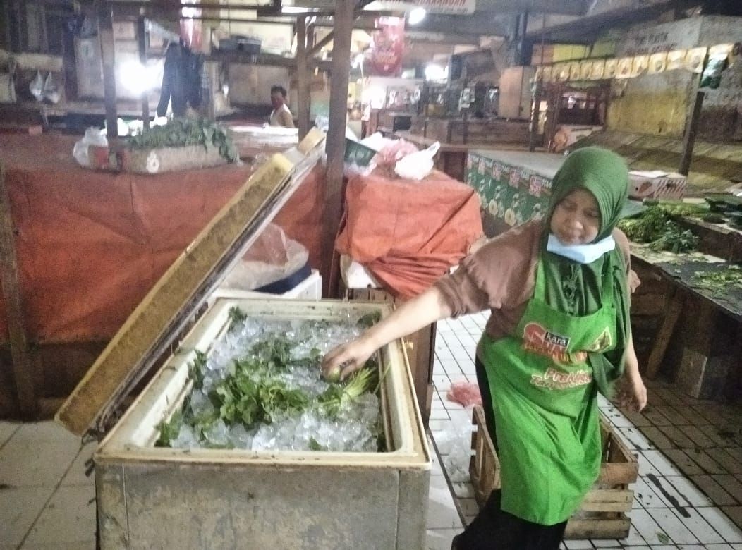 Marni memindahkan sayuran yang masih bisa dijual keesokan harinya ke dalam lemari pendingin sederhana. Hanya diisi es batu, tanpa colokan listrik. (dok.windhu)