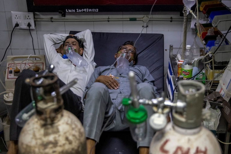 Dua pasien covid-19 yang harus berbaring bersama di atas sebuah ranjang (Source. Reuters.com)