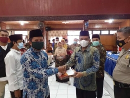 Wabup Padang Pariaman Rahmang menyerahkan bingkisan zakat dalam acara launching gerakan cinta zakat. (foto dok facebook edo syaputra)