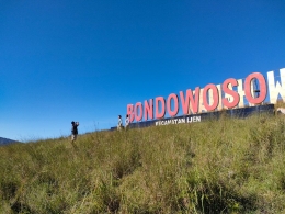 Wisatawan berfoto di depan tulisan Kawah Wurung Bondowoso. (foto: Alex)