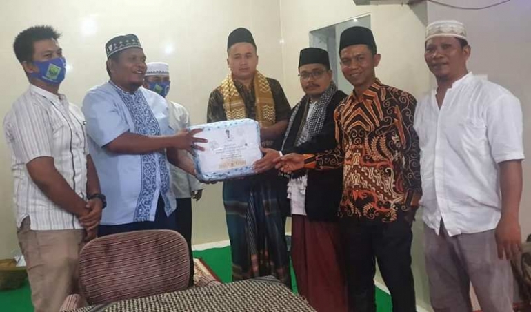 Walinagari Lubuk Alung Hilman H bersama perangkatnya menyerahkan paket sumbangan TSR yang dipimpinnya ke pengurus surau. (foto dok facebook hilman iqra')