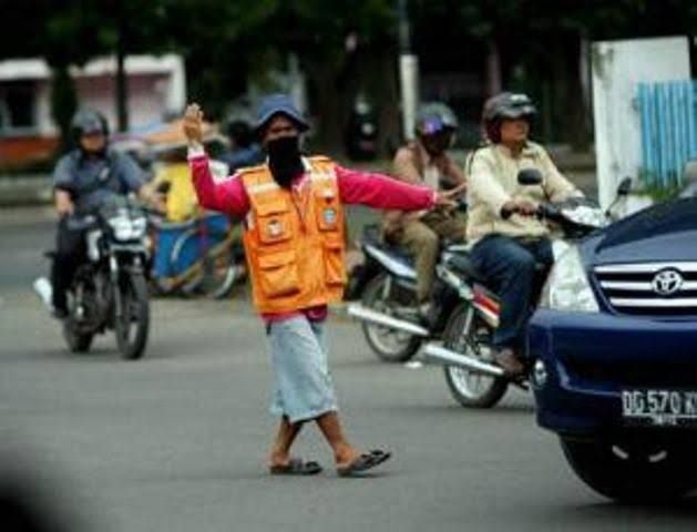 Seorang Tukang Parkir Yang Mengarahkan Kendaraan. Sumber Hipwee.com