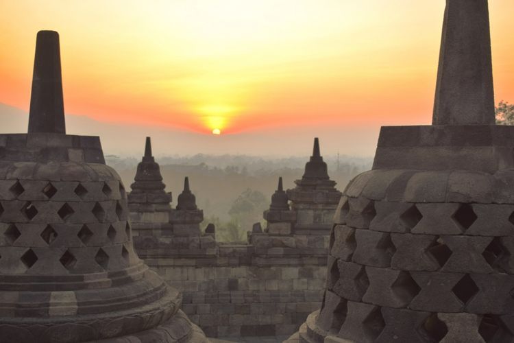 Menyentuh salah satu arca di dalam stupa. | Dokumentasi Shutterstock yang diambil dari kompas.com