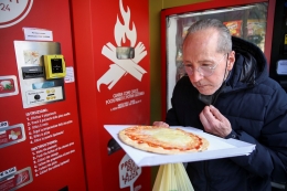 Seorang pelanggan mencoba pizza buatan mesin ini. Sumber: Yara Nardi / Reuters