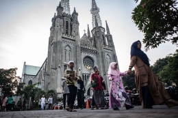 Toleransi dan kebebasan beragama. Sejumlah warga berjalan menuju Masjid Istiqlal untuk melaksanakan Salat Idul Adha seusai memarkir kendaraan bermotornya di Gereja Katedral, Jakarta, Minggu (11/8/2019) - (ANTARA FOTO/APRILLIO AKBAR)