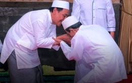 KH Zuhri Zaini (kanan) dan KH M Hasan Mutawakkil Alallah. Sumber: https://www.nu.or.id/post/read/106235/warga-internet-kagumi-foto-salaman-dua-kiai)