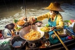 Seorang perempuan yang sedang memasak pad thai di atas sampan | Foto diambil dari Alamy via South China Morning Post
