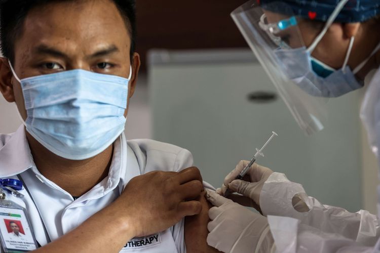 Petugas kesehatan menerima suntikan vaksin corona buatan Sinovac di Rumah Sakit Siloam TB Simatupang, Jakarta Selatan, Kamis (14/1/2021). Vaksin Sinovac telah mendapatkan izin penggunaan darurat atau emergency use authorization (EUA) dari Badan Pengawas Obat dan Makanan (BPOM). Dengan izin penggunaan darurat ini, vaksin CoronaVac produksi Sinovac Life Science Co.Ltd.China dan PT Bio Farma (Persero) dapat digunakan untuk program vaksinasi di Indonesia.(KOMPAS.com/GARRY LOTULUNG)