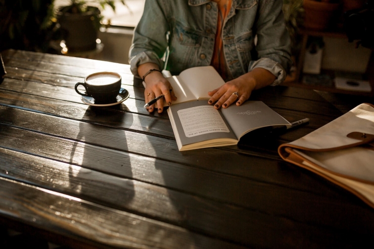 Membaca buku seraya menikmati kopi (Ilustrasi: unsplash)