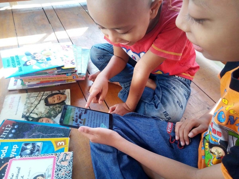 Membaca buku lewat aplikasi di gawai, cara baru membangkitkan minat baca anak. (Foto: dok. pri) 