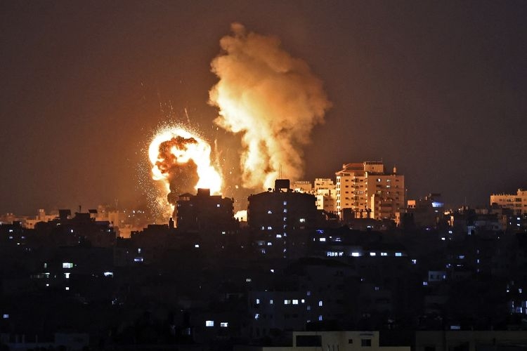 Foto in menunjukkan ledakan akibat serangan udara di Jalur Gaza yang dikontrol Hamas, pada Senin (10/5/2021). Israel melancarkan serangan udara di Gaza untuk membalas serangan roket dari Hamas, dalam bentrokan terbaru di Masjid Al-Aqsa Palestina.(AFP PHOTO/MAHMUD HAMS via KOMPAS.com)