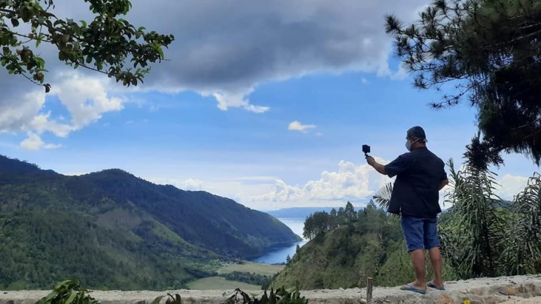 Langit Tanah Toba dan Danau Toba menyempurnakan keindahan di Adian Nalambok. Perbukitan serta pepohonan yang rimbun, membuat kita leluasa melepaskan seluruh penat. Foto: budi tanjung