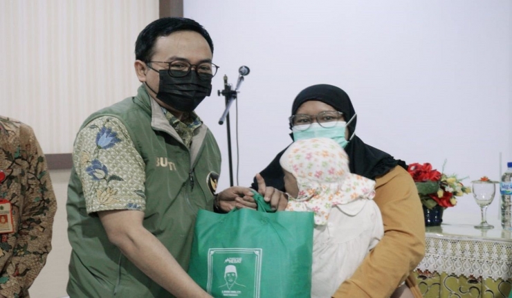 Bupati Pamekasan Baddrut Tamam menyerahkan bingkisan kepada orang tua peserta operasi bibir sumbing, Jumat (28/5/2021)-dokpri