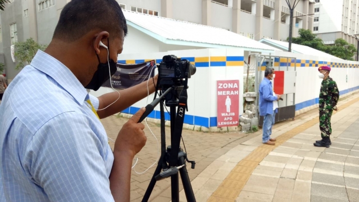 Saya dan Letnan Kolonel Laut M. Arifin berbincang tentang lonjakan pasien Covid-19 di pintu gerbang zona merah Rumah Sakit Darurat Covid (RSDC) Wisma Atlet Kemayoran. Didik Wiratno memvideokan kami dengan Sony A7 Mark III. Posisi kamera rada jauh tak masalah, karena perbincangan kami bisa di-record dengan baik oleh clip on Sennheiser. Foto: Erwin Hadi