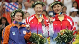 Foto kenangan saat Zhang Ning (tengah) meraih medali emas Olimpiade 2004 usai mengalahkan Mia Audina (kiri) di final/Foto: Stuart Franklin/Getty Images