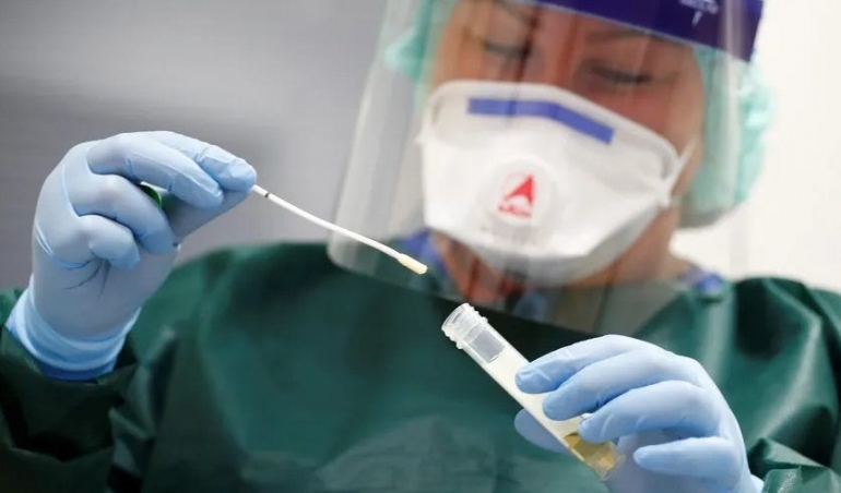 Ilustrasi petugas kesehatan menunjukkan hasil rapid antigen. Foto: suarasurabaya.net.