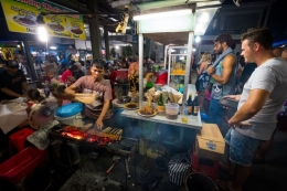 Ilustrasi wisatawan asing yang sedang mencoba makanan lokal ketika berwisata. (sumber: SHUTTERSTOCK/RPMASSE via kompas.com)