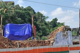 Kondisi crane yang terbalik di proyek rel ganda Bogor-Sukabumi ditutupi terpal biru, Senin (7/6/2021).(KOMPAS.COM/RAMDHAN TRIYADI BEMPAH)