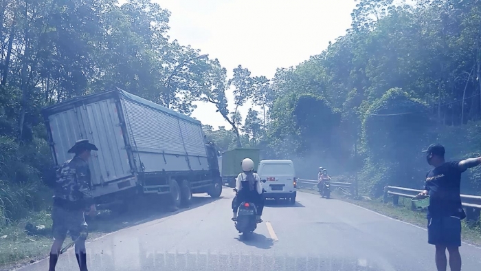 Sebuah truk besar gagal memanjak sehingga mundur di tepi jalan