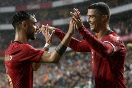 Ronaldo dan Bruno Fernandes berselebrasi setelah mencetak gol ke gawang Israel dalam laga uji coba (Foto AFP/Jose Manuel Ribeiro via Kompas) 