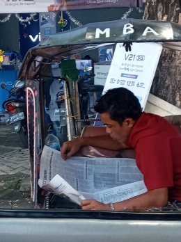 Pengemudi becak motor membaca koran, keren (dokpri)