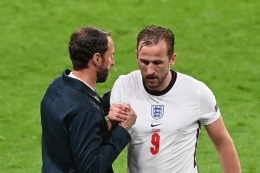 Penyerang timnas Inggris, Harry Kane, memberi salam kepada pelatih Gareth Southgate setelah ia diganti pada laga Grup D Euro 2020 kontra Skotlandia di Stadion Wembley pada Sabtu (19/6/2021) dini hari WIB.(AFP/FACUNDO ARRIZABALAGA) 