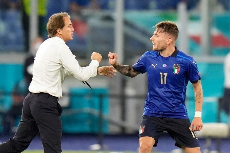 Pelatih Timnas Italia, Roberto Mancini, memberi selamat kepada Ciro Imobile setelah ia mencetak gol ketiga Azzurri pada laga Grup A Euro 2020 di Estadio Olimpico pada Kamis (17/6/2021) dini hari WIB. (Foto: AFP/ALESSANDRA TARANTINO via Kompas.com)