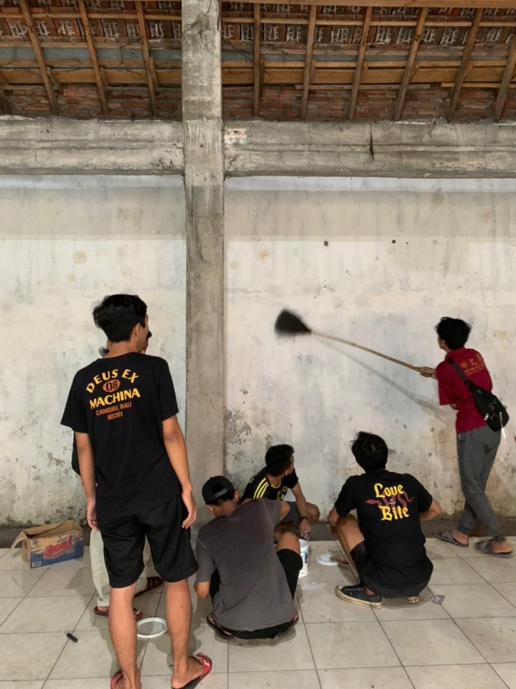 Proses Pembersihan Kotoran di Tembok Balai Dusun Kepuh Selatan Sebelum di Catoleh Mahasiswa KKN UM 2021 dan Karang Taruna