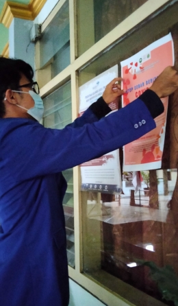 Penempelan poster oleh mahasiswa KKN UM di Desa Jenggolo 2020/2021 (Dok. Pribadi)
